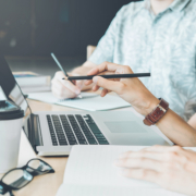 Zwei Menschen am Schreibtisch mit Laptop und Notizen